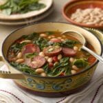 A bowl of swamp soup recipe with fresh herbs on a rustic table