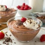 Chocolate protein pudding with whipped cream and raspberries